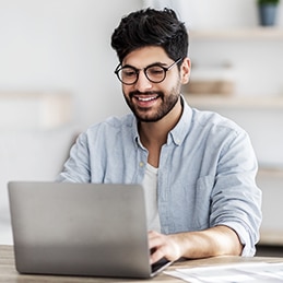 Person tippt auf einem Laptop